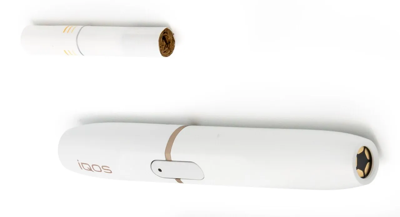 Bir HEETS tütün çubuğu ve IQOS cihazı